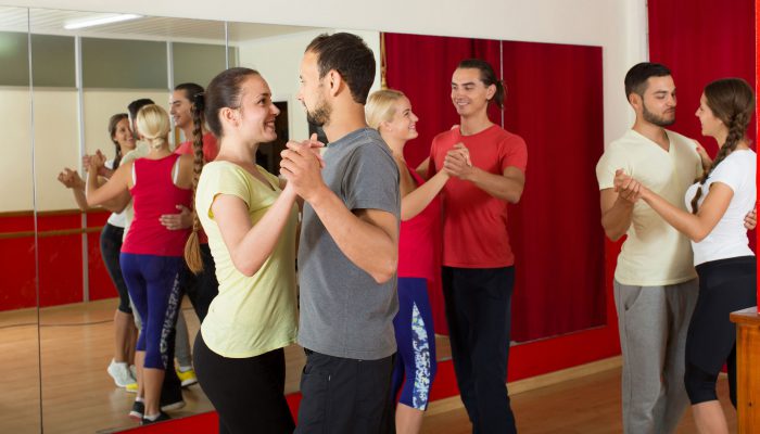 Group of  people dancing rumba in studio